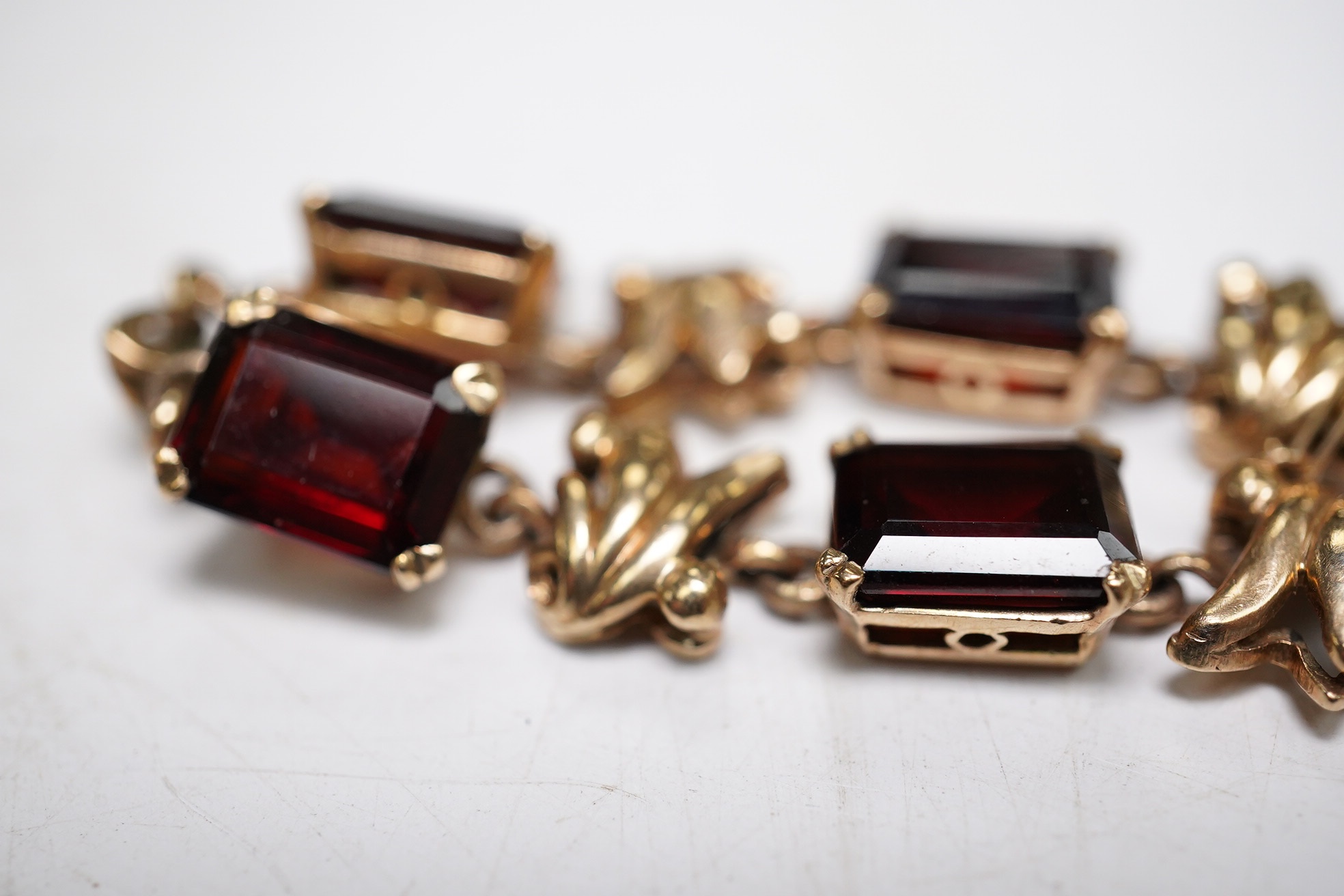 A yellow metal and nine stone emerald cut garnet? set bracelet, 18cm, gross weight 16.5 grams. Condition - fair